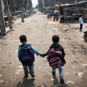 Children walk to school in the slum district of Madanpur Khadar.